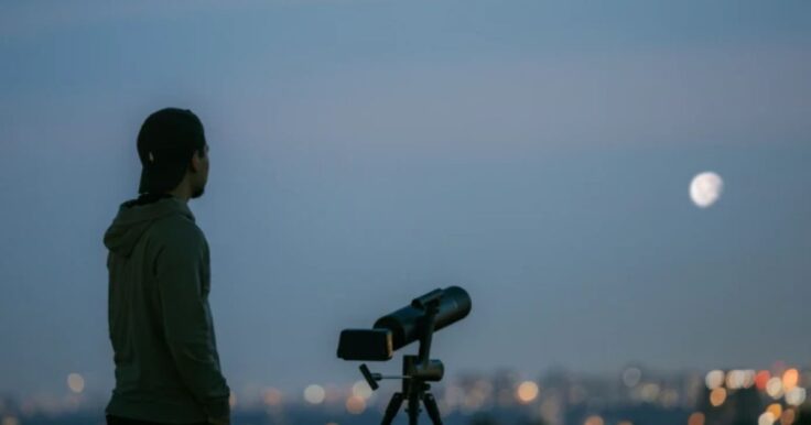 An image of a photographer using the Finder TW2 to take a picture of the moon at twilight.